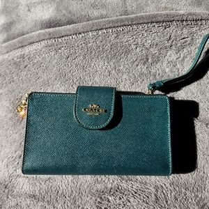 Coach wallets with wrist strap and charms.